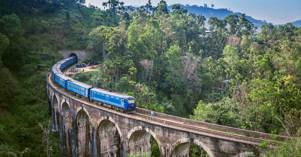<p> If you’ve seen photos of passengers hanging out of a blue train surrounded by dense, green foliage, you’ve likely seen the Sri Lanka Railways journey from Kandy to Ella in Sri Lanka. Although it may not be recommended to hang from objects moving at high speeds, you wouldn’t want to miss the views on this train ride between the central city of Kandy and the small southern town of Ella. </p> <p> The ride takes about seven hours and offers views of tea plantations, green hills, bridges, and villages. It’s recommended not to book first-class tickets for your itinerary, as you won’t have the experience of mingling with the locals and having open windows.</p>