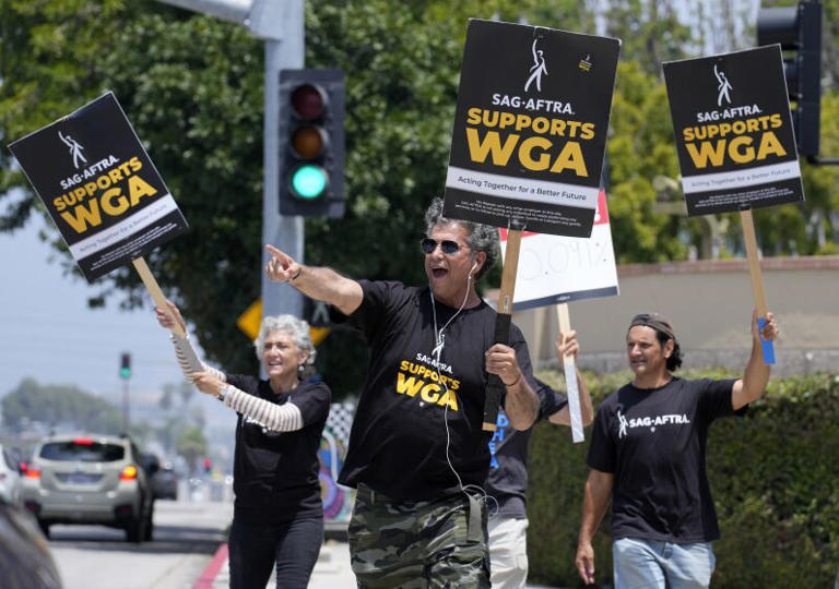 Screen Actors Guild members take part in a Writers Guild rally May 22 outside Warner Bros. Studios in Burbank. ((Chris Pizzello / Associated Press))