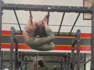 Woman is hanging from monkey bars in a backbend doing pull ups!