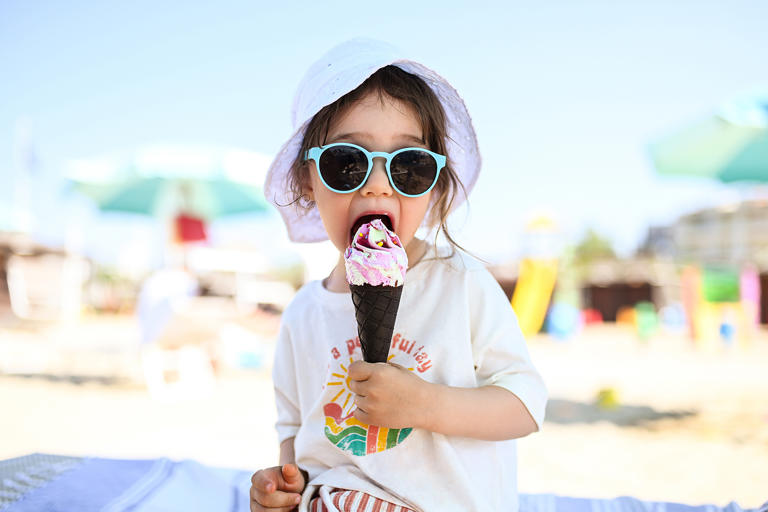 Beautiful little baby girl eating ice cream