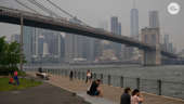 People sit in Brooklyn Bridge Park during heavy smog in New York on June 6, 2023. Smoke from Canada's wildfires has engulfed the Northeast and Mid-Atlantic regions of the US, raising concerns over the harms of persistent poor air quality.