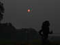 June 8 | Arlington, Va.  The rising sun appears orange behind a morning runner.