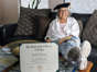 Joan Bernstein, 88, wears her tam from her doctoral hooding ceremony alongside her doctor of philosophy in humanities diploma at her home in Garland, Texas, Wednesday, May 31, 2023.