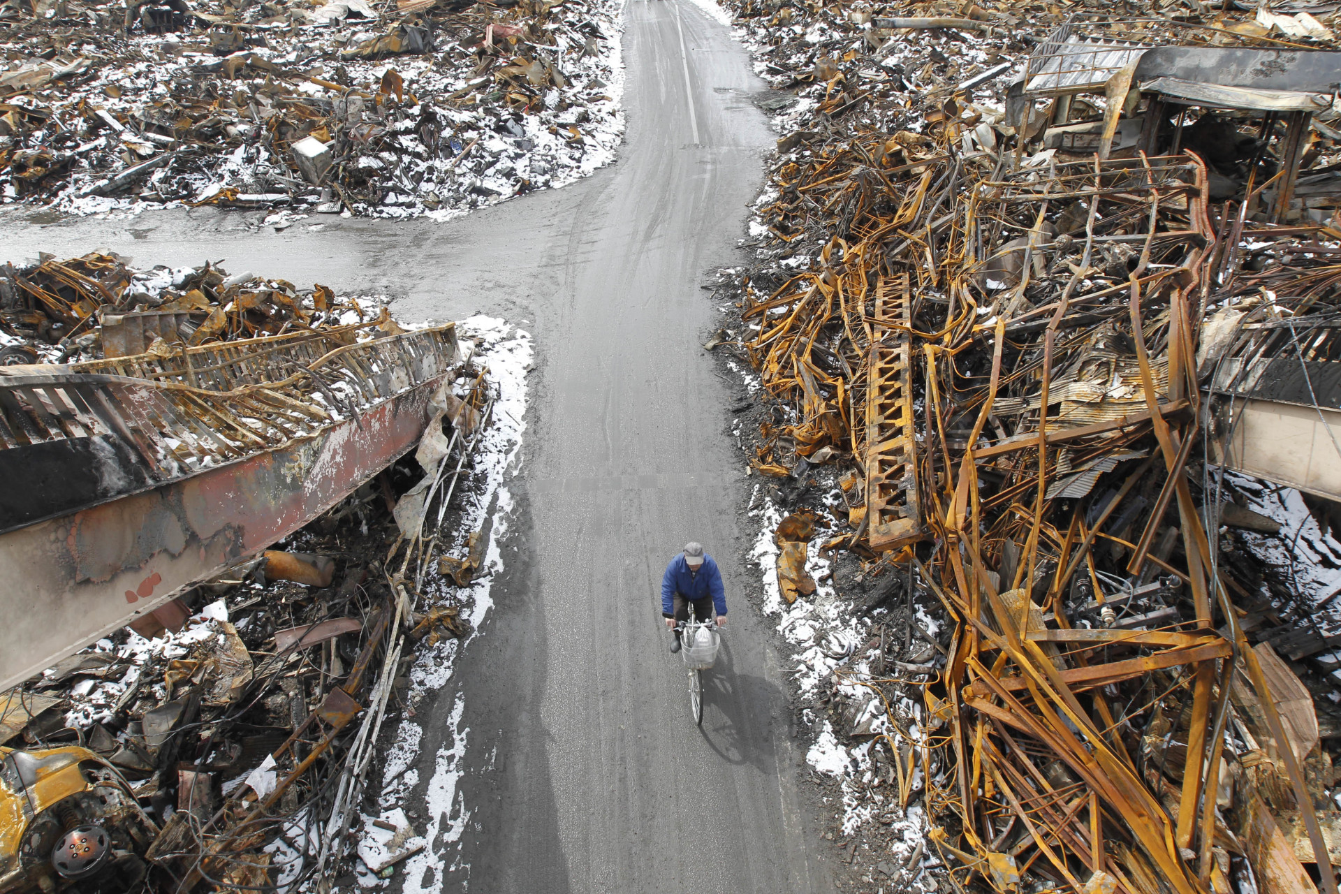 Un homme avance à bicyclette dans une zone touchée par le séisme et le tsunami, à Kesennuma, dans le nord du Japon.