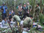 In this photo released by Colombia's Armed Forces Press Office, soldiers and Indigenous men tend to the four Indigenous brothers who were missing after a deadly plane crash, in the Solano jungle, Caqueta state, Colombia, Friday, June 9, 2023. Colombian President Gustavo Petro said Friday that authorities found alive the four children who survived a small plane crash 40 days ago and had been the subject of an intense search in the Amazon jungle. Colombia's Armed Force Press Office via AP
