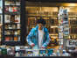 Ein junger Mann schaut sich Bücher in einem Buchladen an. Mit dem Kulturpass bekommen 18-jährige Jugendliche 200 Euro vom Staat.