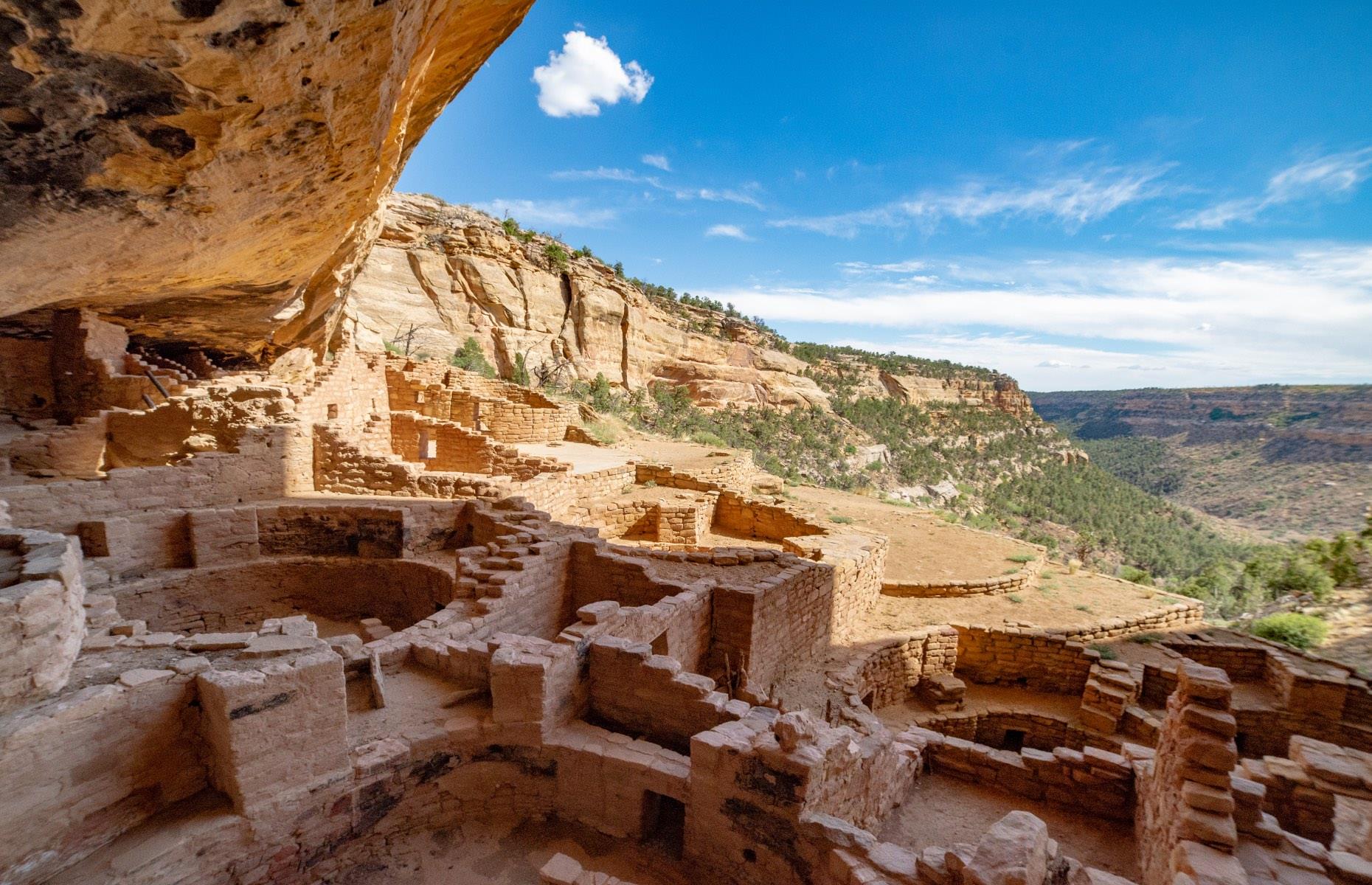 <p>No one knows exactly why the Puebloans started building homes within cliffs. The most common belief is that when the landscape became much drier as the climate became warmer, they decided to move nearer to the water. Also, because the Mesa Verde area is so high and exposed, being tucked under overhanging cliffs offered shelter from the cold winter winds and protection from wildfires. </p>