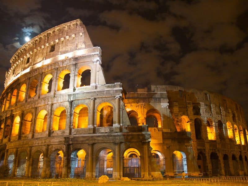 The Colosseum in Rome, Italy, a magnificent ancient amphitheater standing tall against a night sky, showcasing its grand architectural beauty and rich history.