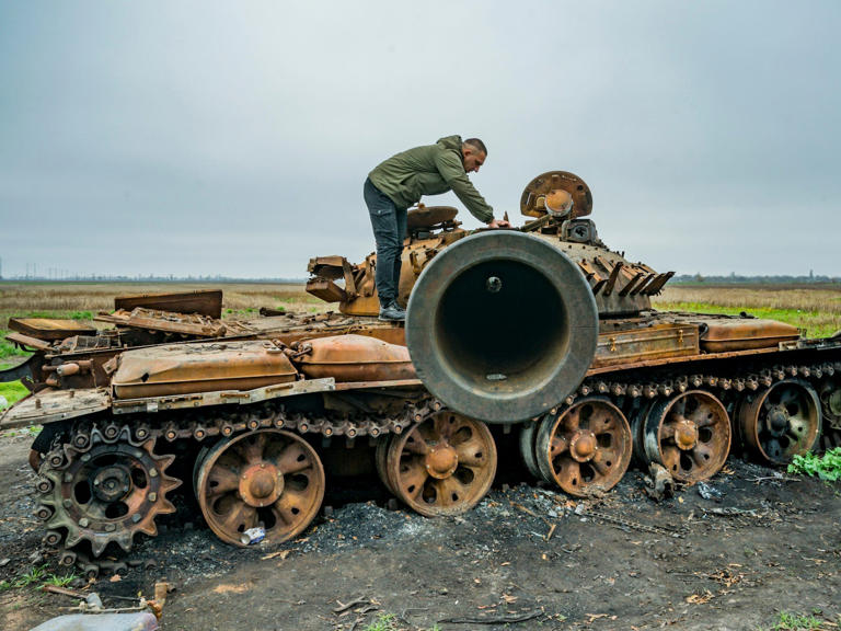 Ein Mann überprüft den Turm eines zerstörten russischen Panzers in der Nähe eines Dorfes in der ukrainischen Provinz Kherson im November 2022.
