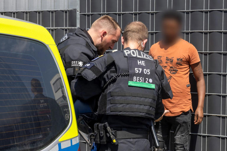 Polizisten kontrollieren am Rande des Eritrea-Festivals in Gießen eine Person.