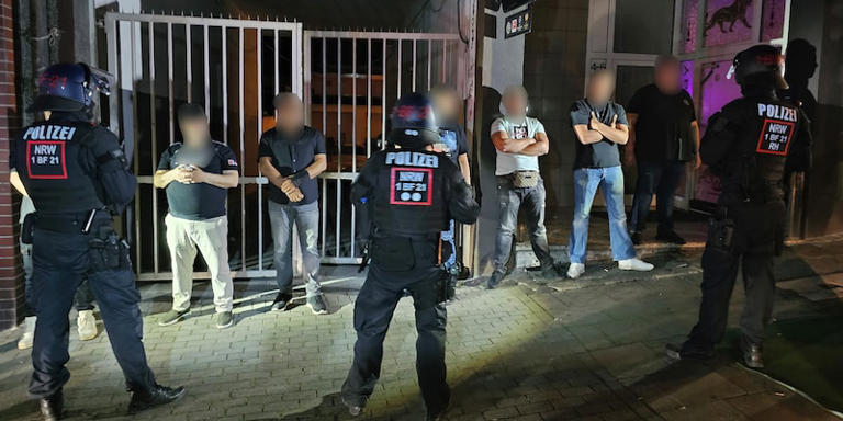 Polizisten bewachen mutmaßliche Teilnehmer einer Schlägerei in der Essener Innenstadt. Markus Gayk/dpa