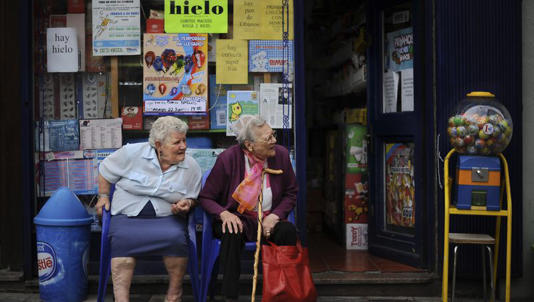 Two elderly women enjoy the day while they rest outside a shop, in Pamplona, northern Spain, on June 17, 2013.