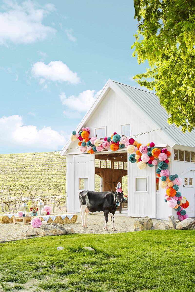 <p>A good ol' country barn party is charming, nostalgic, and totally trending these days. Just look how adorable this barn looks draped in a colorful garland of honeycomb balls and twinkle lights! Farm animals optional.</p>