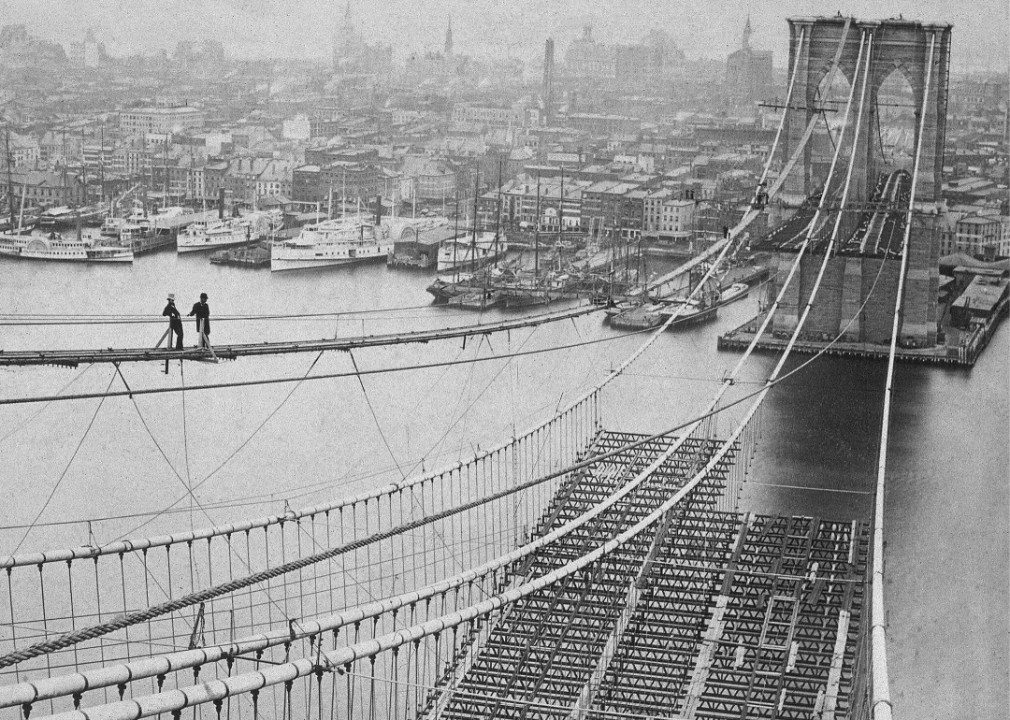 <p>New York's Brooklyn Bridge was constructed in the 19th century to connect Manhattan and Brooklyn over the East River. The 14-year long project, which would be the <a href="https://www.popularmechanics.com/technology/infrastructure/g16639655/a-brief-history-of-bridges-from-stone-to-suspension/">first steel suspension bridge</a>, was based on the designs of German-born civil engineer John Augustus Roebling. This photo shows the construction of the bridge as it nears its completion in 1883. The iconic part of the New York skyline took 600 workers and cost more than $320 million in today's dollars.</p>