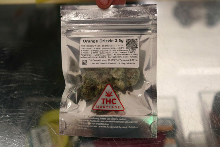 An employee at the Gold Leaf store in Annapolis, Md., holds a package of cannabis on June 26, 2023. The store, which has been selling marijuana for medicinal purposes, began selling cannabis recreationally on July 1 for people 21 and older.