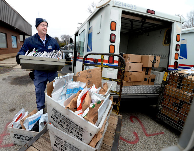 Letter Carrier Steve Homa loads up his mail truck with letters and packages for delivery at the post office in Chatham, Illinois, on East Walnut Street Tuesday Dec. 13, 2022.