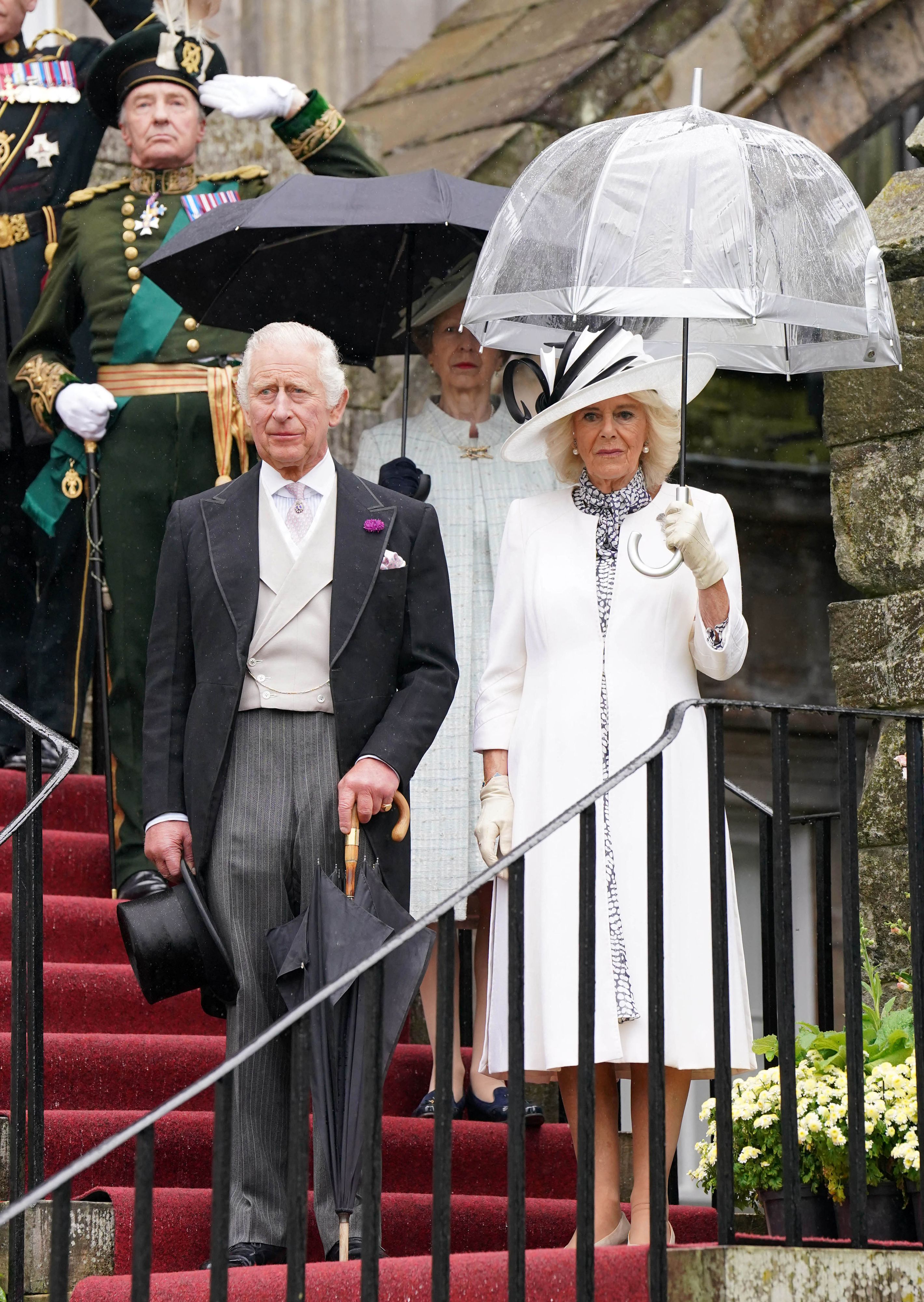 <p>King Charles III and Queen Camilla paused for the national anthem as they hosted guests at a rainy garden party at the Palace of Holyroodhouse in Edinburgh, Scotland, on July 4, 2023. The monarch and his consort were in Scotland for the first annual Royal Week of his reign where they undertook a range of engagements celebrating community, innovation and history. </p>