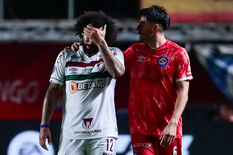 Marcelo (i) de Fluminense se lamenta tras cometer una falta a Luciano Sánchez de Argentinos Juniors, en un partido de los octavos de final de la Copa Libertadores.