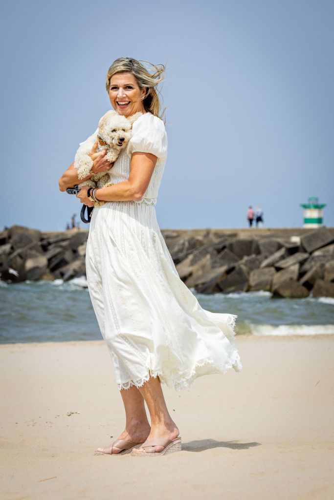 <p>For the royal family's summer photos at Zuiderstrand, Queen Maxima opted for an elegant take on beachy whites—and perfectly coordinated with her pup, Mambo. </p>