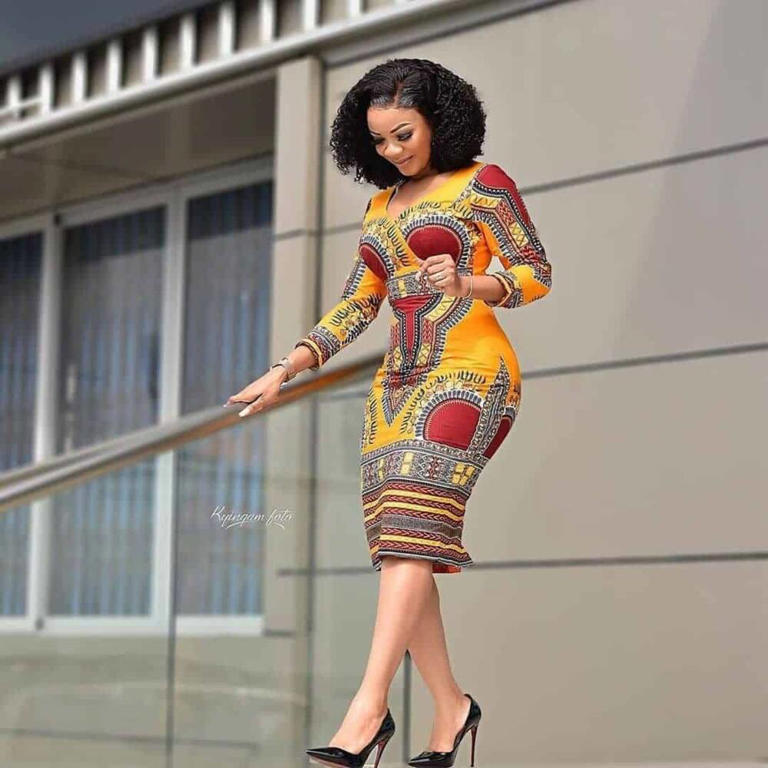 Stylish lady wearing a short Kampala gown climbs down the stairs. Photo: ThriveNaija Source: Instagram