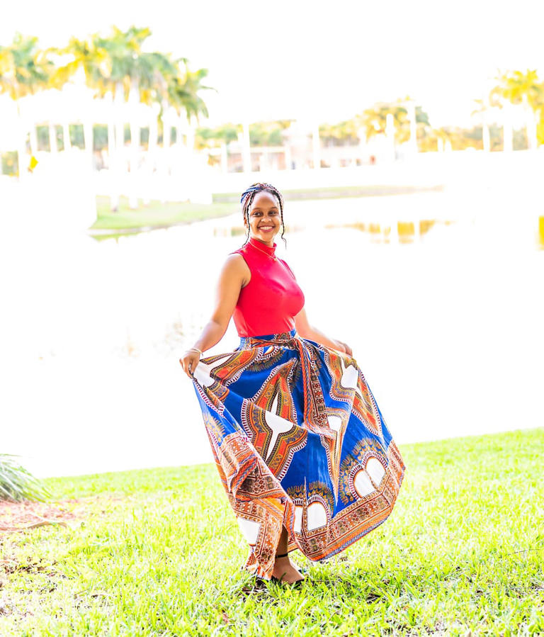 Beautiful young woman in happy outdoor portrait wearing traditional Kampala maxi dress to celebrate Kwanzaa. Photo: Lisa5201 Source: Getty Images