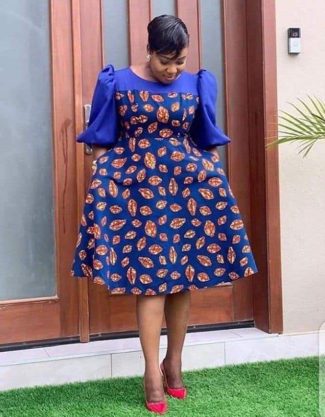 Black lady wearing a blue flare dress with red heels. Photo: Afrikrea Source: Instagram