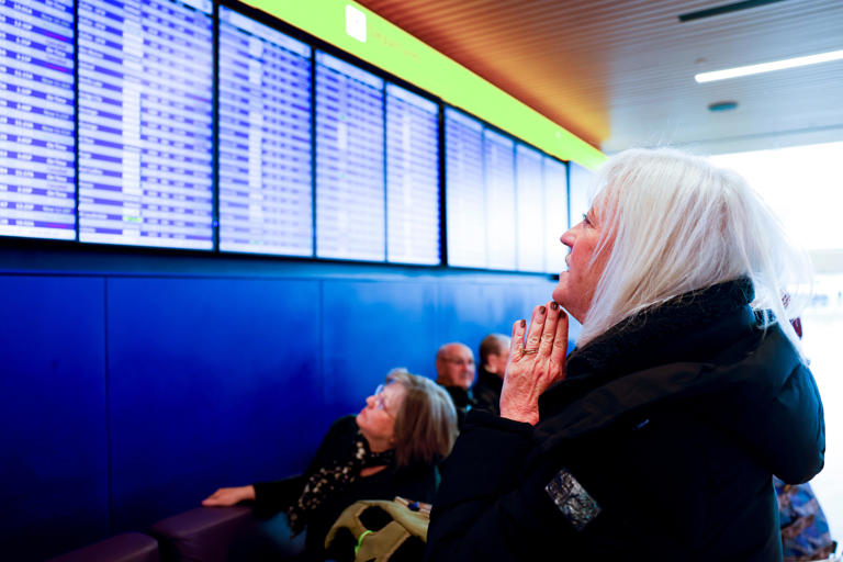 DENVER, CO - FEBRUARY 22: Cathi Vinson looks at a departures board at Denver International Airport showing canceled and delayed flights as she hopes to fly home to Houston during a winter storm on February 22, 2023 in Denver, Colorado. (Photo by Michael Ciaglo/Getty Images)