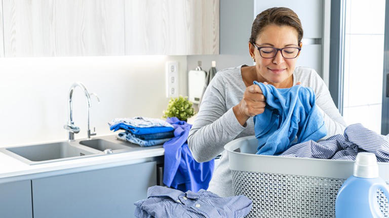 Happy woman smelling laundry