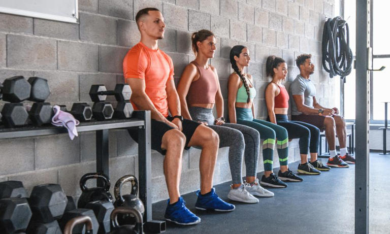 People performing wall sits at a gym. Photograph: AzmanL/Getty Images