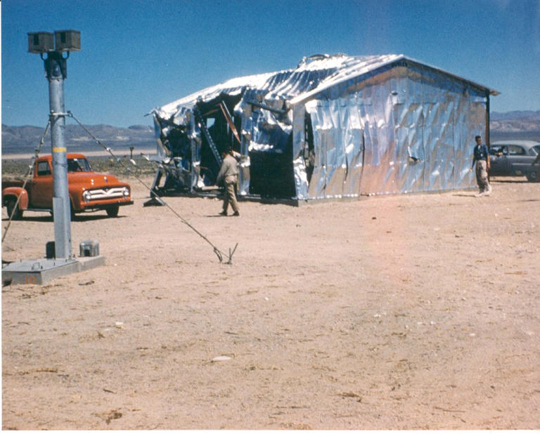 A photo provided to AFP shows an aluminum building damaged by a nuclear blast on May 5, 1955 in Operation Teapot. In the foreground is an armored camera tower set up to record the effects of the explosion National Museum of Nuclear Science and History