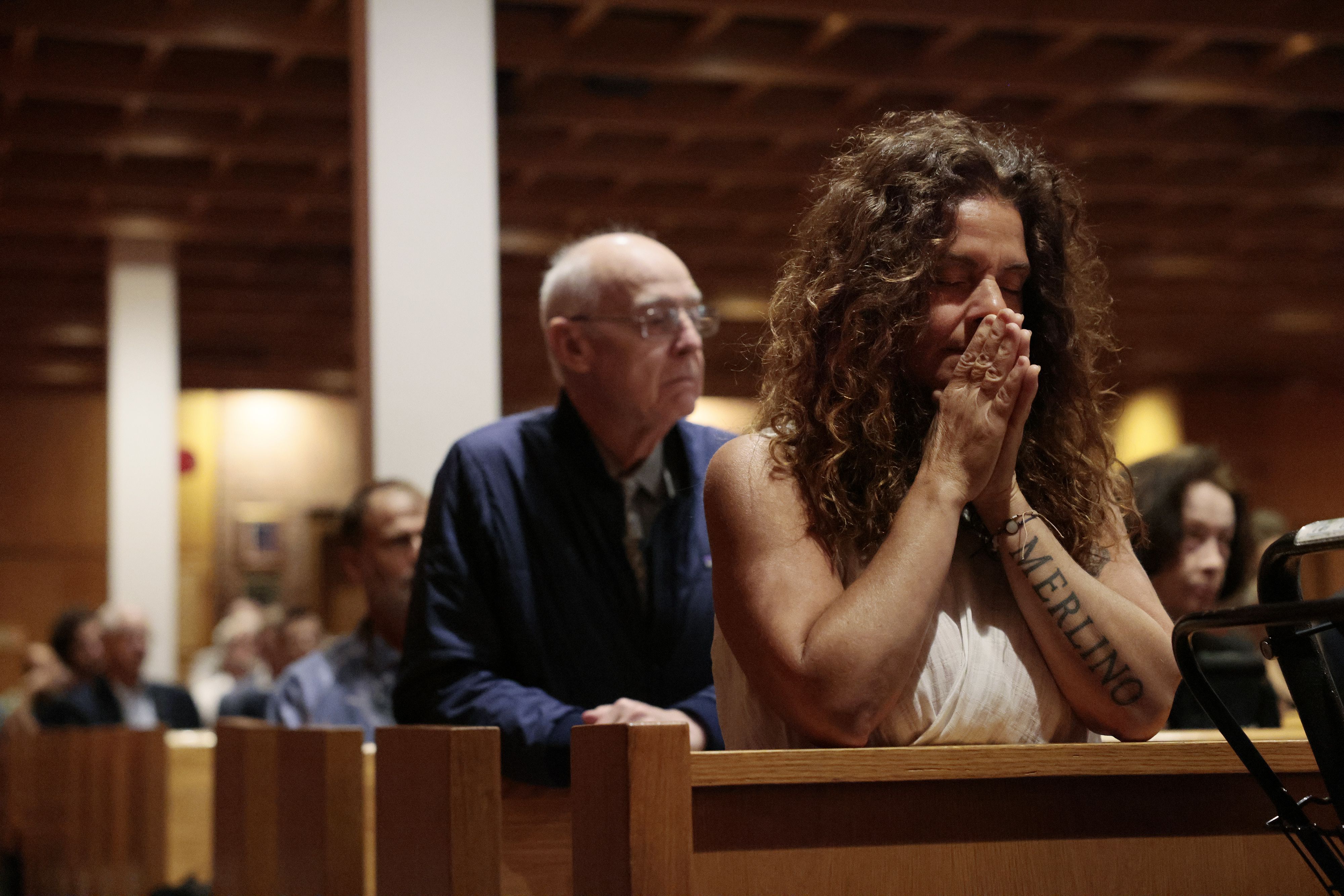 A woman clasped her hands in prayer during a memorial service Sunday at Logan Airport's Our Lady of the Airways chapel for the passengers and crew who were killed in 1973 on Delta Flight 723.