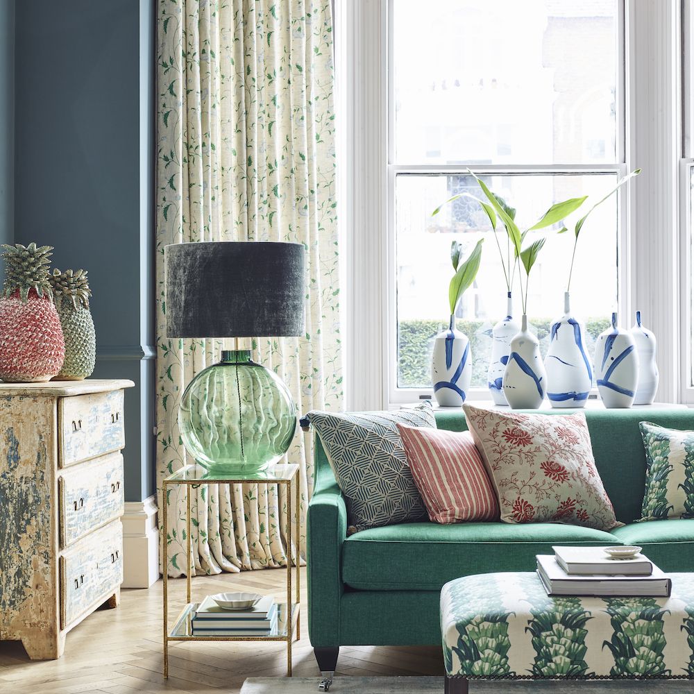 <p>                     Greens and blues have always been a popular colour combination and can sit effortlessly together. Using colour blocks of blue on the walls and green on the sofa grounds the room with a classic combination, whilst the addition of a pop of dark coral gives the room an extra design dimension.                   </p>                                      <p>                     This leaf green sofa and matching footstool gives the room a grown up, sophisticated feel, whilst the pops of coral on soft furnishings and ceramics gives it a modern twist. Oversized lampbase, vases and decorative jars in the same mix of colours adds a contemporary edge.                   </p>