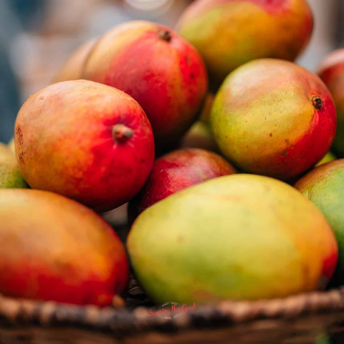 <b>mango</b> fruit, whole fruit in background cut up fruit in the foreground. 