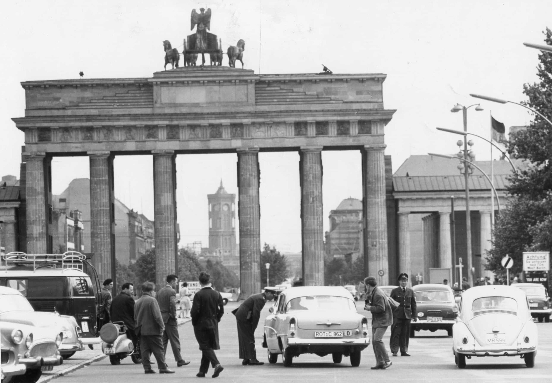 <p>Im Bild: Westberliner Polizeibeamte, hier am 21. August 1960, sprechen mit Autofahrern, bevor sie das Brandenburger Tor nach Ostberlin durchqueren. Etwa ein Jahr später wurde das Wahrzeichen der Stadt, das Teil der Berliner Mauer werden sollte, von der DDR geschlossen.</p>