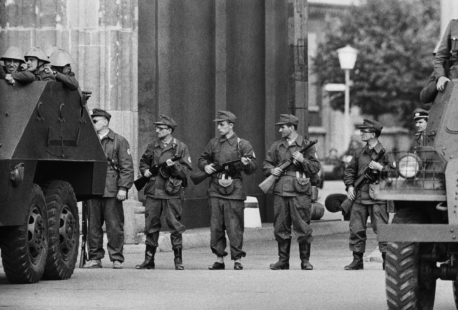 <p>Im Bild: Mitglieder der ostdeutschen paramilitärischen Organisation <em>Kampfgruppe der Arbeiterklasse</em> bewachen den Grenzübergang in der Nähe des Brandenburger Tors.</p>