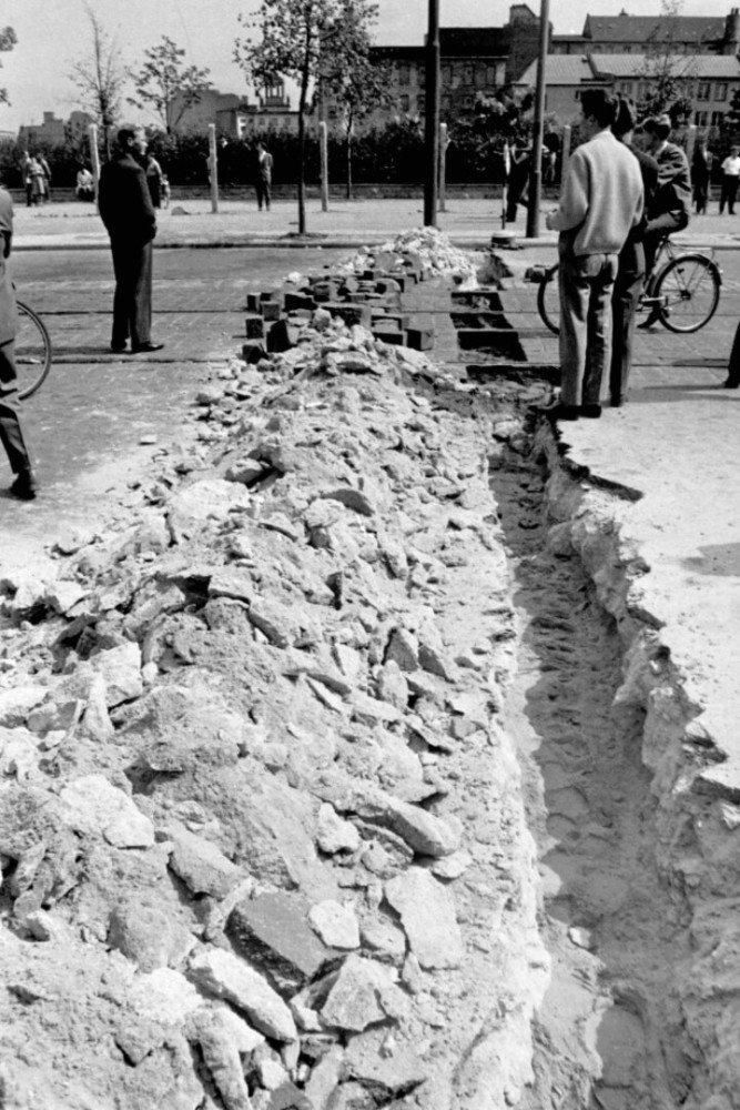 <p>Im Bild: Der Straßenbelag des Potsdamer Platzes wurde zerschlagen, um ein Fundament für die Mauer zu schaffen. Auch die Straßenbahnschienen wurden nicht verschont.</p>