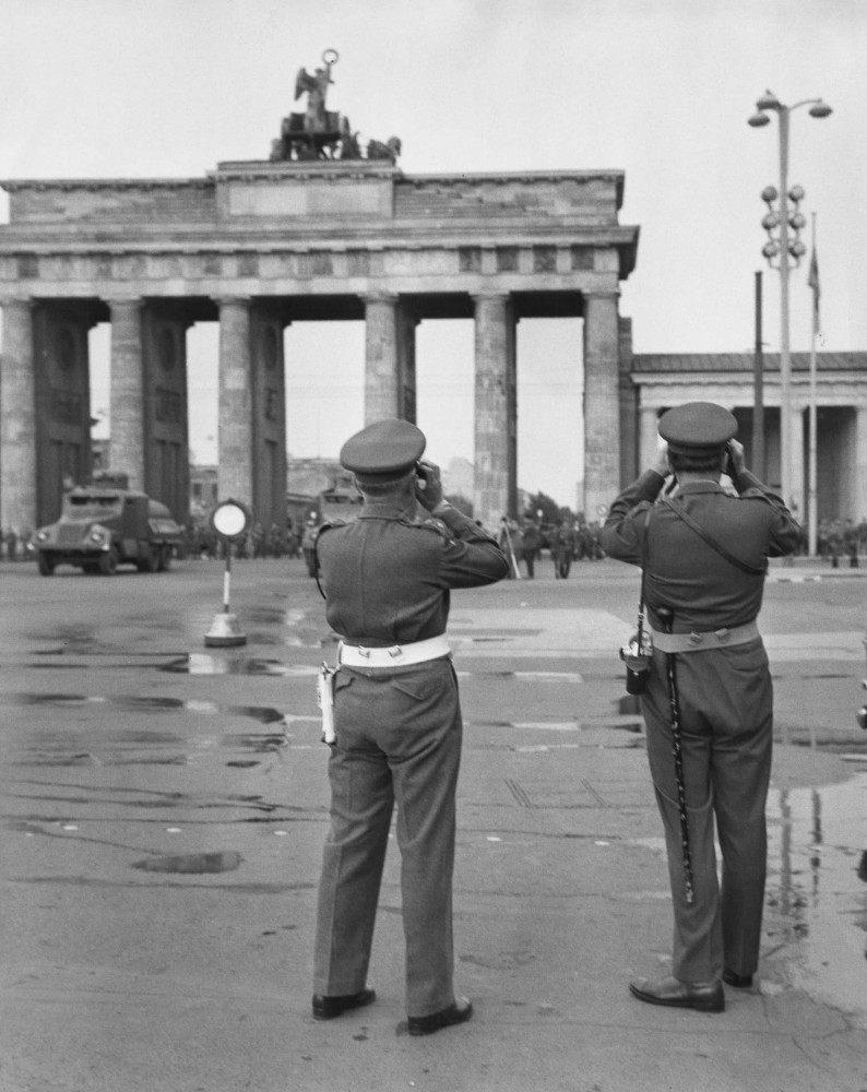 <p>Im Bild: Zwei hochrangige Mitglieder der britischen Militärpolizei beobachten das Brandenburger Tor, nachdem es von den ostdeutschen Sicherheitskräften geschlossen wurde, während die Mauer Gestalt annimmt.</p>