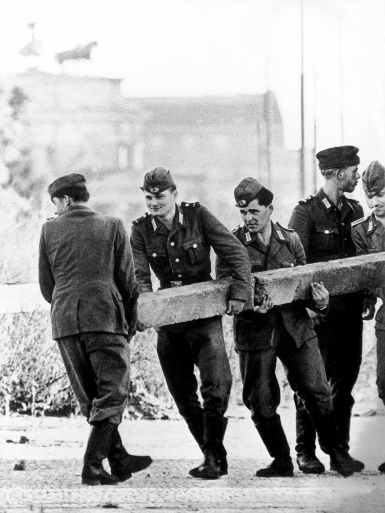 <p>Im Bild: Angehörige der ostdeutschen Sicherheitskräfte beginnen mit der Verbarrikadierung der Grenzübergänge nach West-Berlin mit Betonpfeilern.</p>