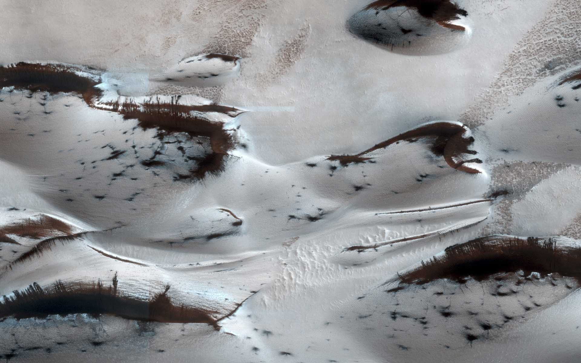 Estas são as dunas de areia mais setentrionais de Marte e podem ser vistas quando emergem de uma cobertura invernal de gelo (seco) sazonal de dióxido de carbono.