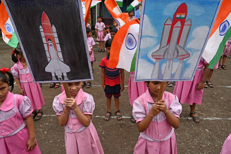 Students wave India’s national flag as they hold posters in support of the Chandrayaan-3 spacecraft in Mumbai on August 22, 2023. INDRANIL MUKHERJEE/AFP via Getty Images