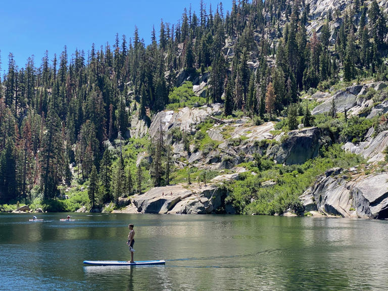 A paddle boarder takes in the views as he paddles on the Upper Angora Lake in South Lake Tahoe.