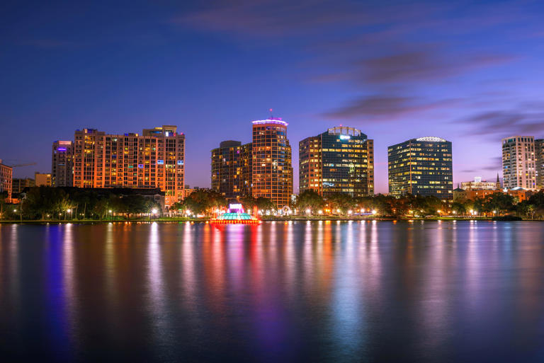 A colorful sunset and the city skyline viewed from Lake Eola Park in Orlando, Florida.