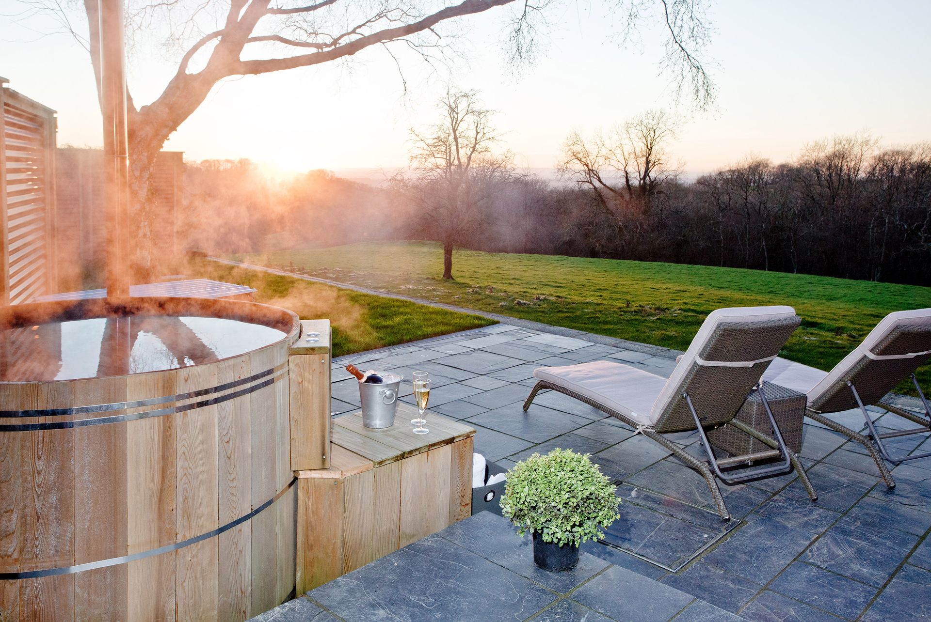 <p>                     This paved space has everything needed for a pared-back chill-out zone. Views of the lawn can be enjoyed from the traditional tub, while sun loungers nearby are handy for when you need to take a break from the bubbles – just throw on a white robe and some sliders and chill.                   </p>                                      <p>                     For the winter months, why not add patio heaters? That way, your outdoor area will be transformed into a welcoming spa all year-round.                   </p>