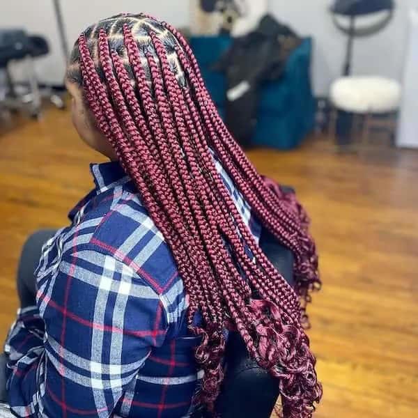 Burgundy knotless braids with curly ends. Photo: @thebraid.boutique_. Source: Instagram