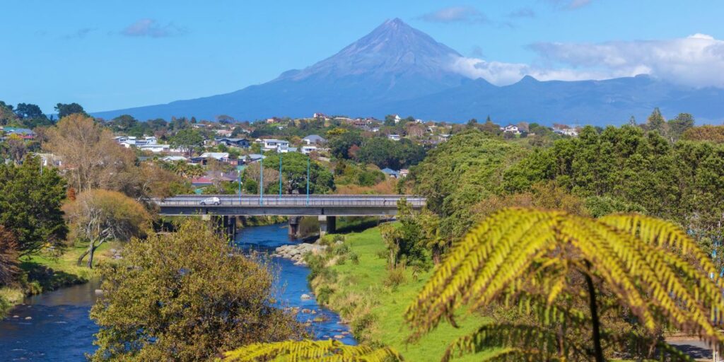 <p>Off the beaten tourist path lies a North Island city: New Plymouth.</p><p>New Plymouth is a small city on the North Island’s west coast. It’s known for its black sand surf beaches and its hiking trails in Mount Egmont National Park, which is home to the volcanic mountain of Mount Taranaki.</p><p>While in New Plymouth, a top thing to do is to walk or cycle along the gorgeous New Plymouth Coastal Walkway, where you’ll also find the Te Rewa Rewa Bridge, shaped like a whale skeleton and a breaking wave.</p><p>A must-visit place in New Plymouth is Mount Egmont National Park, where you can hike to Dawson Falls and the Wilkies Pools through a moss-laden forest. Another great hike is the trail to Pouakai Tarns, a small alpine lake that reflects Mount Taranaki on a calm day.</p><p>After a day of activities around New Plymouth, relax with a delicious meal and craft beer at Shining Peak Brewery, one of the best craft breweries on North Island, New Zealand.</p>