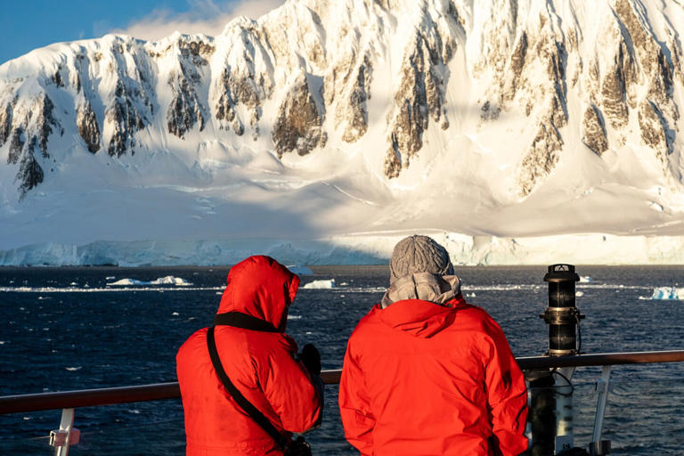 Guests take in Antarctica from the deck of the Sylvia Earle .