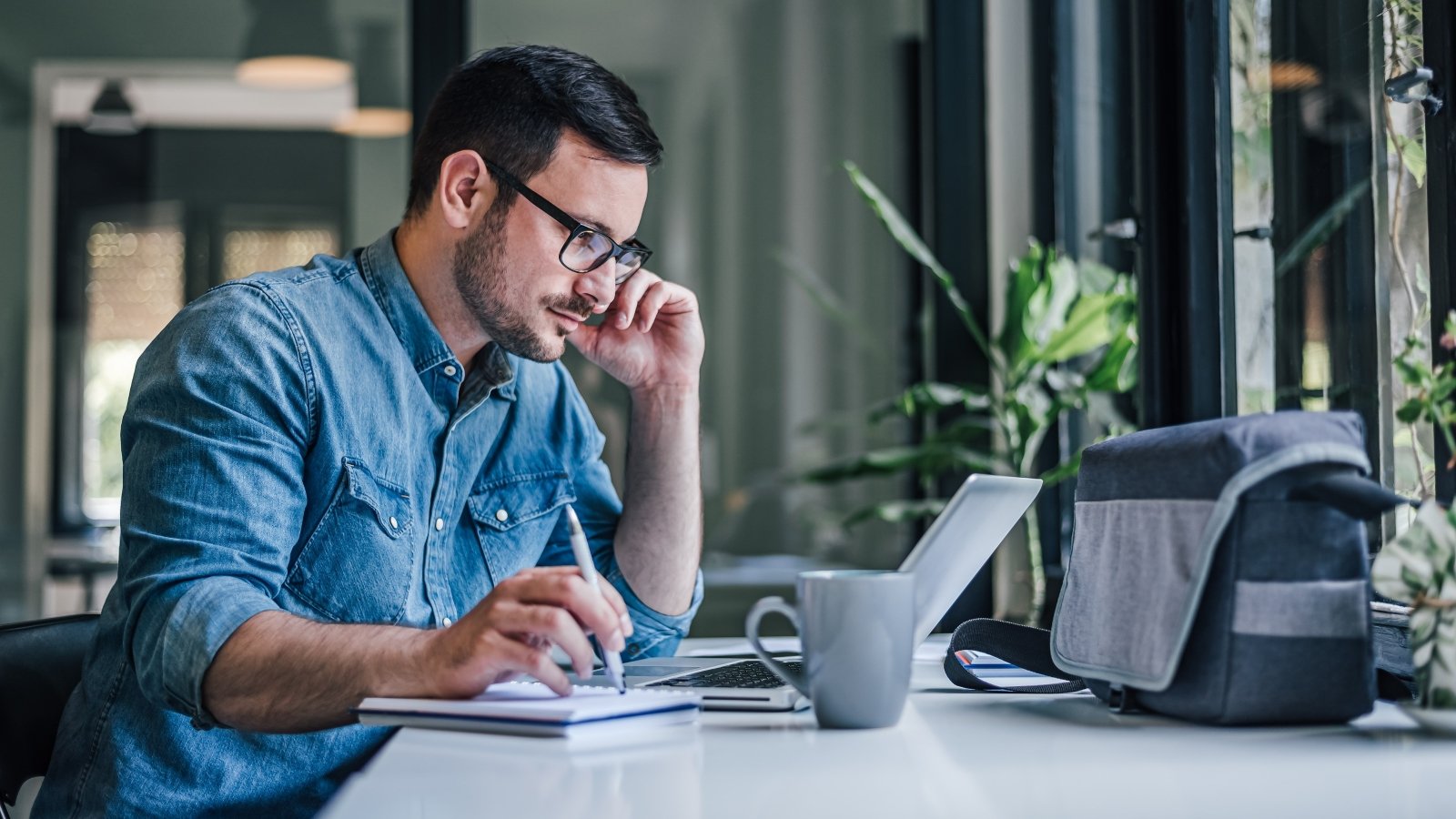 Предприниматель кто он. Мужчина записывает. Photo of a thoughtful entrepreneur. Thinking man with Laptop.