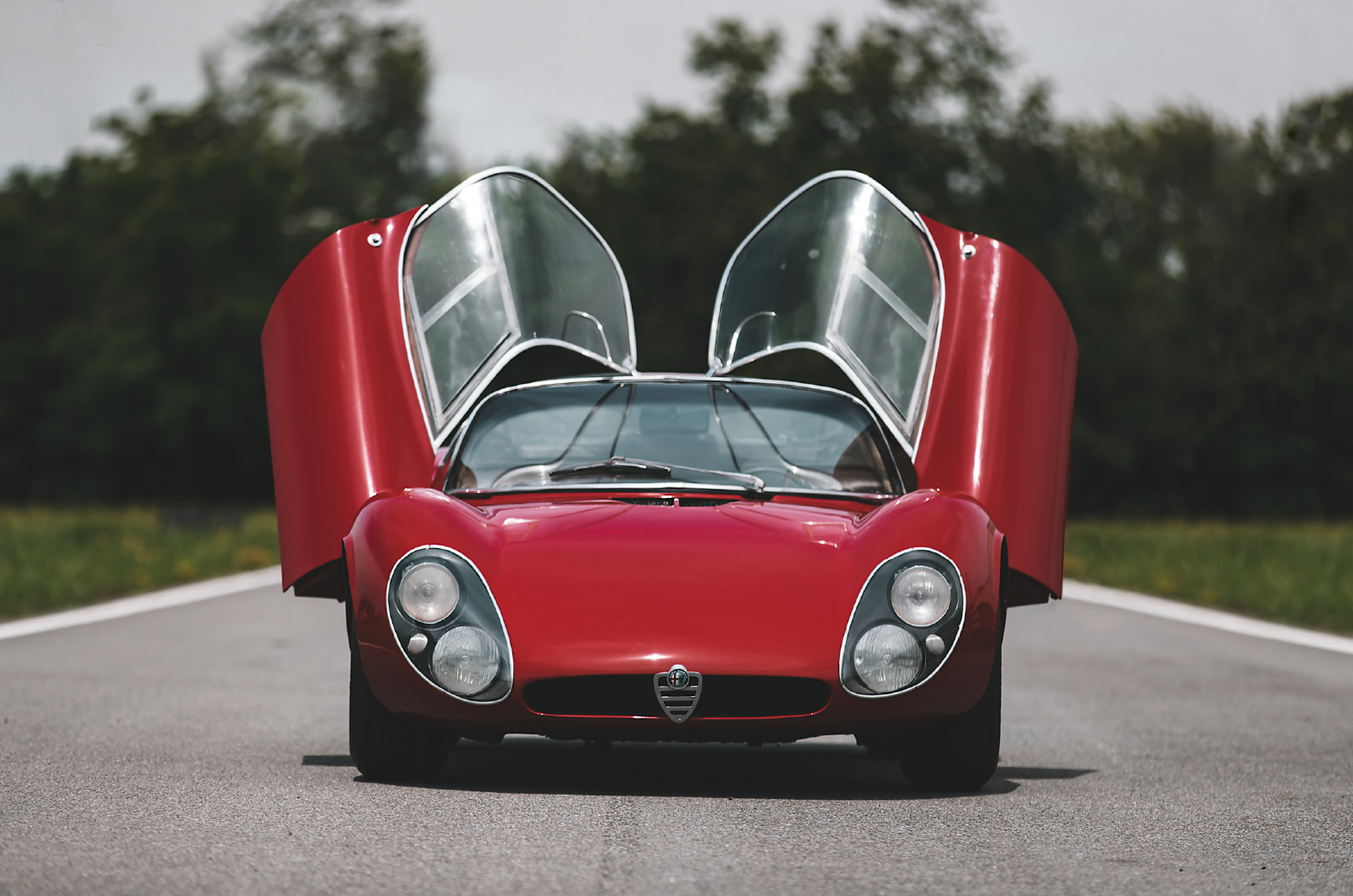 <p>What originally began as the Tipo 33 race car, morphed into a roadgoing 33 Stradale version. Over a two-year production run, just 18 left the Alfa Romeo factory.</p>  <p>At the time it was one of the fastest and most expensive road-legal supercars. It was constructed with an aluminum body and weighed just 700KG (about 1540LB).</p>  <p>Most notably, the Alfa Romeo 33 Stradale is remembered for its oval-shaped headlights and roof-hinged butterfly doors, with window panels that wrapped around to the roof.</p>  <p>When the doors are closed it creates a split-sunroof illusion and an uninterrupted view.</p>  <p>Doors open or closed, the 33 Stradale is praised as a particularly stunning example of Italian automotive design, inspired by Alfa Romeo’s racing heritage.</p>