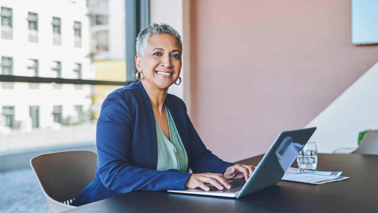 Senior business woman typing on laptop, replying to emails and working on a proposal in an office at work. Portrait of a mature female boss, manager and ceo browsing the internet and planning online