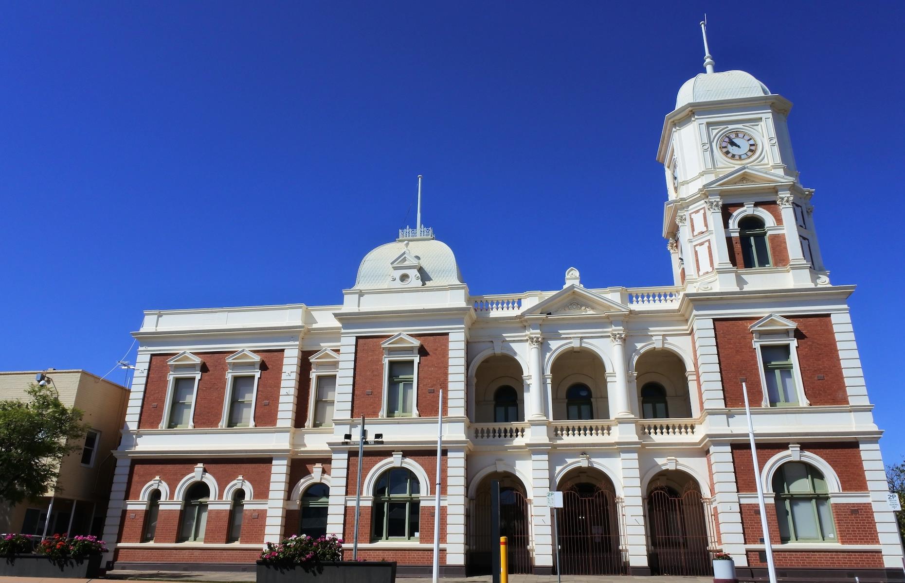 <p>The twin mining towns became the city of Kalgoorlie-Boulder in 1989. Kalgoorlie’s Hannan Street is lined with the grand facades of turn-of-the-century architecture constructed as the city’s coffers flourished. Pop into the 1897 Palace Hotel for a cold beer and a taste of the past or immerse yourself in gold-mining history at the Museum of the Goldfields. Both centers have beautiful town halls – Boulder’s is home to the Goldfields War Museum (pictured). The biggest wow will come from a gawp at the Super Pit from the lookout. One of the world’s largest open pit gold mines, and the biggest gold mine in Australia, it's part of the so-called Golden Mile where Hannan first struck lucky. </p>